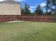 Fenced backyard with green lawn and decorative rock garden and statue at 292 Aylesbury Bv, Mcdonough, GA 30252