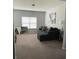 Comfortable living room featuring a plush couch, carpeted floors, and natural light from the window at 292 Aylesbury Bv, Mcdonough, GA 30252