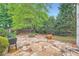 Backyard patio featuring stone pavers, a fire pit, lush landscaping, and a charming outdoor space at 1025 Ector Nw Dr, Kennesaw, GA 30152