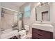 Bathroom featuring a shower and tub combination with a sliding glass door, modern sink, and a toilet next to a window at 1025 Ector Nw Dr, Kennesaw, GA 30152