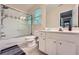 Bathroom featuring a shower-tub combo with glass doors, toilet, and vanity with ample storage at 1025 Ector Nw Dr, Kennesaw, GA 30152