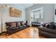 Cozy living room with hardwood floors, leather sofas, piano, bay window and decorative lighting at 1025 Ector Nw Dr, Kennesaw, GA 30152