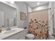 Bathroom with single sink vanity, commode, tub/shower combination and floral shower curtain at 2066 Patterson Park Rd, Decatur, GA 30033