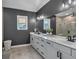 Sleek bathroom with a double vanity, modern lighting, and a large mirror, accented by dark grey walls at 2066 Patterson Park Rd, Decatur, GA 30033