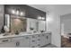 Bright bathroom featuring a double vanity with modern fixtures, a large mirror and a gray accent wall at 2066 Patterson Park Rd, Decatur, GA 30033