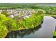 Aerial view of homes in community with a lake and surrounding trees at 4039 Tallow Pl, Woodstock, GA 30188