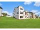 Lush green backyard with view of a modern home featuring a covered porch and walkout basement at 4039 Tallow Pl, Woodstock, GA 30188
