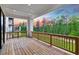 Spacious outdoor deck with wood floors and wood railing overlooking green scenery at 4039 Tallow Pl, Woodstock, GA 30188