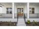 Charming front porch featuring double doors, white columns and painted brickwork at 4039 Tallow Pl, Woodstock, GA 30188