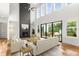 Bright living room boasting hardwood floors, high ceilings, modern fireplace, and doors leading to a deck at 4039 Tallow Pl, Woodstock, GA 30188