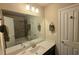 This bathroom offers a single vanity with quartz countertop, tiled shower/tub, and neutral decor at 7165 Winthrop Rd, Alpharetta, GA 30005