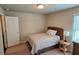 This bedroom has a twin bed, a door to the left, a small table, and a window to provide natural light at 7165 Winthrop Rd, Alpharetta, GA 30005