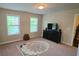 This carpeted bonus bedroom has 2 windows and is ready for you to use as an office, media room, or playroom at 7165 Winthrop Rd, Alpharetta, GA 30005