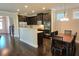 Modern kitchen with dark cabinets, stainless steel appliances, breakfast bar, and adjacent dining area at 7165 Winthrop Rd, Alpharetta, GA 30005