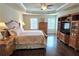 Spacious main bedroom features trey ceilings, ceiling fan, dark hardwood floors and a beautiful built-in entertainment center at 7165 Winthrop Rd, Alpharetta, GA 30005
