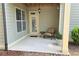 Cozy outdoor patio with neutral furniture, a small table, and well-manicured landscaping at 7165 Winthrop Rd, Alpharetta, GA 30005