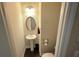 Half bathroom with pedestal sink, oval mirror, and neutral color scheme at 7165 Winthrop Rd, Alpharetta, GA 30005