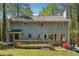 The back exterior of the home features a deck, large windows, and siding, set against a backdrop of mature trees at 1366 Maple Ridge Dr, Suwanee, GA 30024