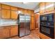 Spacious kitchen with a stainless steel refrigerator, wood cabinets, and modern appliances for culinary enthusiasts at 1366 Maple Ridge Dr, Suwanee, GA 30024