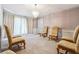 Formal living room with plush carpet, decorative chandelier, and ample seating creating a cozy ambiance at 1366 Maple Ridge Dr, Suwanee, GA 30024