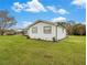 Well-maintained backyard showcasing a white home and a lush green lawn on a sunny day at 1871 Weems Rd, Locust Grove, GA 30248