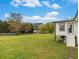 Spacious backyard with lush green grass and a glimpse of the white home exterior at 1871 Weems Rd, Locust Grove, GA 30248
