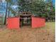 Open-sided barn with red siding for equipment storage at 1871 Weems Rd, Locust Grove, GA 30248