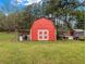 Red barn with white trim provides secure shelter or storage, surrounded by green grass at 1871 Weems Rd, Locust Grove, GA 30248