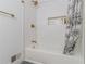 Bright bathroom featuring white tiled walls, a shower/tub combo, and stylish gold fixtures at 1871 Weems Rd, Locust Grove, GA 30248