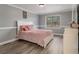 Cozy bedroom with grey walls, wood-look flooring, a large window, and a comfortable-looking bed at 1871 Weems Rd, Locust Grove, GA 30248