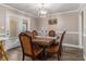 Elegant dining room with a wooden table, chandelier, and access to the outdoors at 1871 Weems Rd, Locust Grove, GA 30248