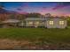 Charming single-story home with a covered porch, white siding, and a spacious front yard at dusk at 1871 Weems Rd, Locust Grove, GA 30248