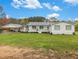 Charming single-story home with a covered porch, white siding, and a spacious front yard at 1871 Weems Rd, Locust Grove, GA 30248