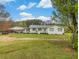 Charming single-story home with a covered porch, white siding, and a spacious front yard at 1871 Weems Rd, Locust Grove, GA 30248