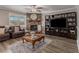 Inviting living room featuring hardwood floors, a stone fireplace, and custom built-in shelving at 1871 Weems Rd, Locust Grove, GA 30248