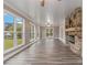Bright and airy living room featuring hardwood floors, a stone fireplace, and large windows at 1871 Weems Rd, Locust Grove, GA 30248