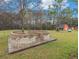 Backyard brick patio with seating surrounding a mature tree at 1871 Weems Rd, Locust Grove, GA 30248