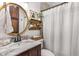 Cozy bathroom featuring a marble countertop, dark wood vanity, and gold circular mirror at 3675 Peachtree Ne Rd # 9, Atlanta, GA 30319