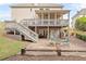 Backyard with a covered deck above a stone patio that offers outdoor seating and entertainment space at 3720 Bridle Ridge Dr, Suwanee, GA 30024