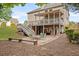 Landscaped backyard with a covered deck, stone patio, seating area, and mature trees at 3720 Bridle Ridge Dr, Suwanee, GA 30024