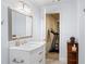 Bathroom featuring a marble vanity, mirror, and an open doorway leading to an exercise room at 3720 Bridle Ridge Dr, Suwanee, GA 30024