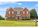 Charming two-story brick home featuring well-manicured landscaping and classic architectural details at 3720 Bridle Ridge Dr, Suwanee, GA 30024