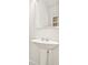 Well-lit bathroom featuring a white pedestal sink and a large mirror at 11112 Benton Woods Dr, Covington, GA 30014