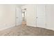 Bedroom featuring neutral carpeting, two closets, a window, and an open doorway at 11112 Benton Woods Dr, Covington, GA 30014