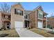 Attractive brick townhome showcasing a one-car garage and well-maintained landscaping at 11112 Benton Woods Dr, Covington, GA 30014