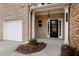 Inviting entryway featuring a black front door, sidelights, and well-lit porch at 11112 Benton Woods Dr, Covington, GA 30014