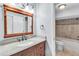 Bathroom with dark wood vanity, granite countertops, with decorative backsplash and tiled walls at 1668 Terrell Ridge Se Dr, Marietta, GA 30067