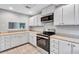 Well-lit kitchen with white cabinets, stainless steel appliances, and tile backsplash at 1668 Terrell Ridge Se Dr, Marietta, GA 30067