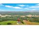 Breathtaking aerial shot highlighting a home surrounded by rolling hills and verdant forests under a clear blue sky at 300 Eminence Peak, Rydal, GA 30171