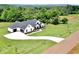 An aerial view captures this farmhouse-style home on an expansive lot, and a long driveway at 300 Eminence Peak, Rydal, GA 30171